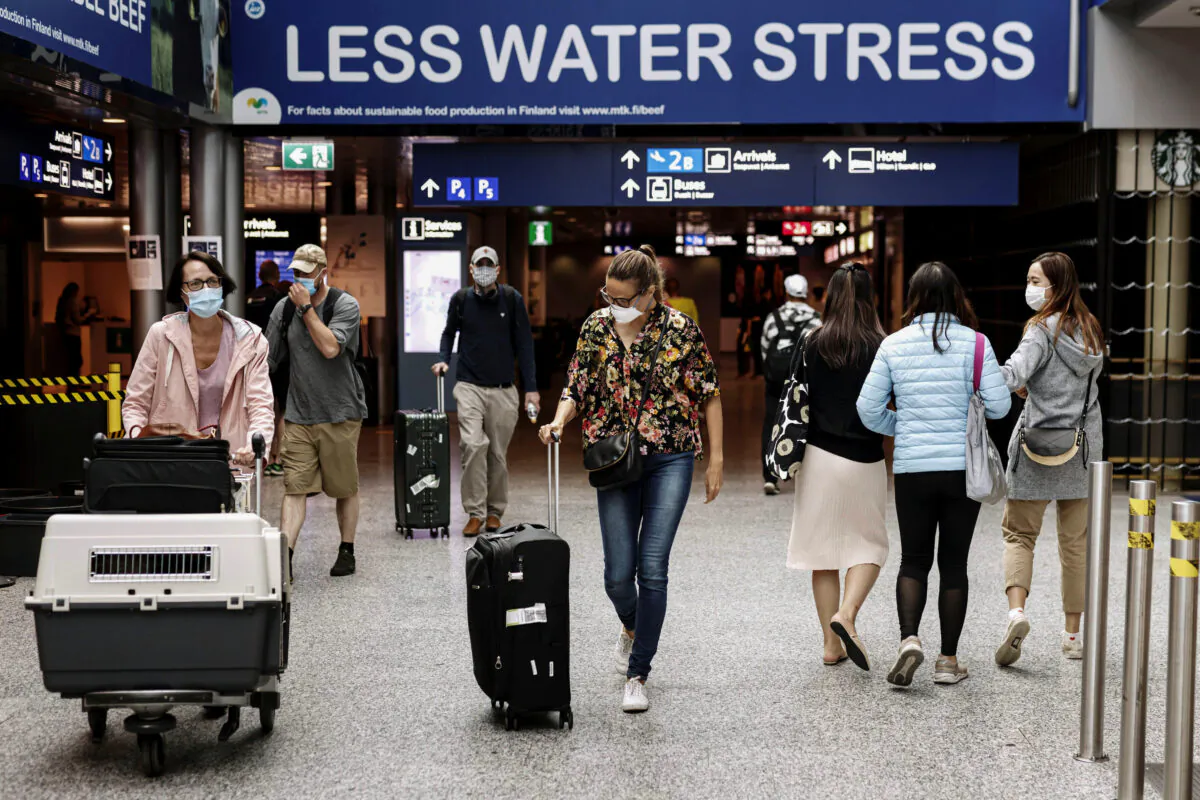 Passengers wearing face masks walk at the Helsinki-Vantaa airport in Vantaa, Finland, on July 13, 2020. (Roni Rekomaa/Lehtikuva/Reuters)