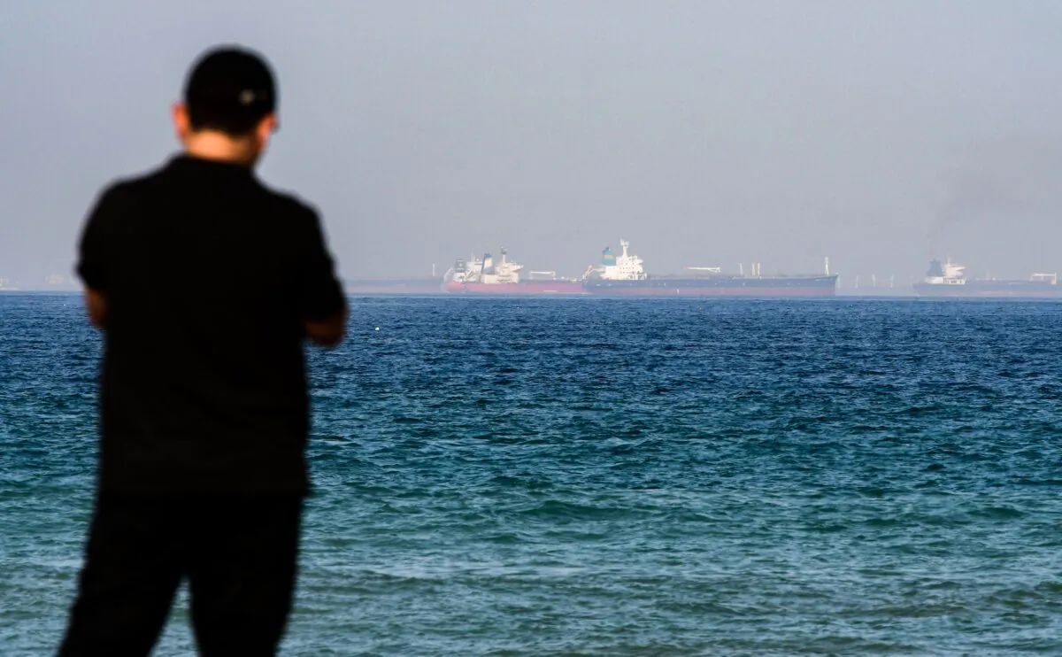 A man stands along a beach as tanker ships are seen in the waters of the Gulf of Oman off the coast of the eastern UAE emirate of Fujairah on June 15, 2019. (Giuseppe Cacace/AFP via Getty Images)