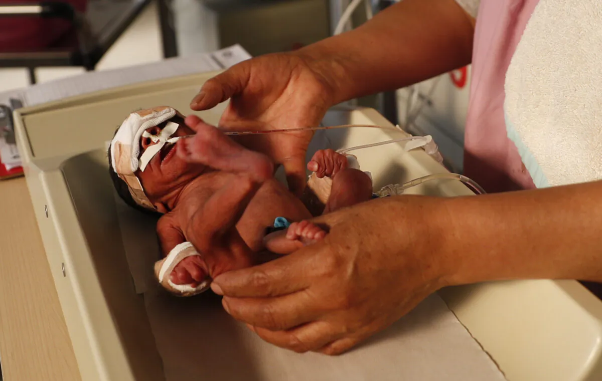 A nurse attends to a newborn baby in the intensive care unit of the Women's Hospital maternity ward in La Paz, Bolivia on Aug. 13, 2020. (AP Photo/Juan Karita)
