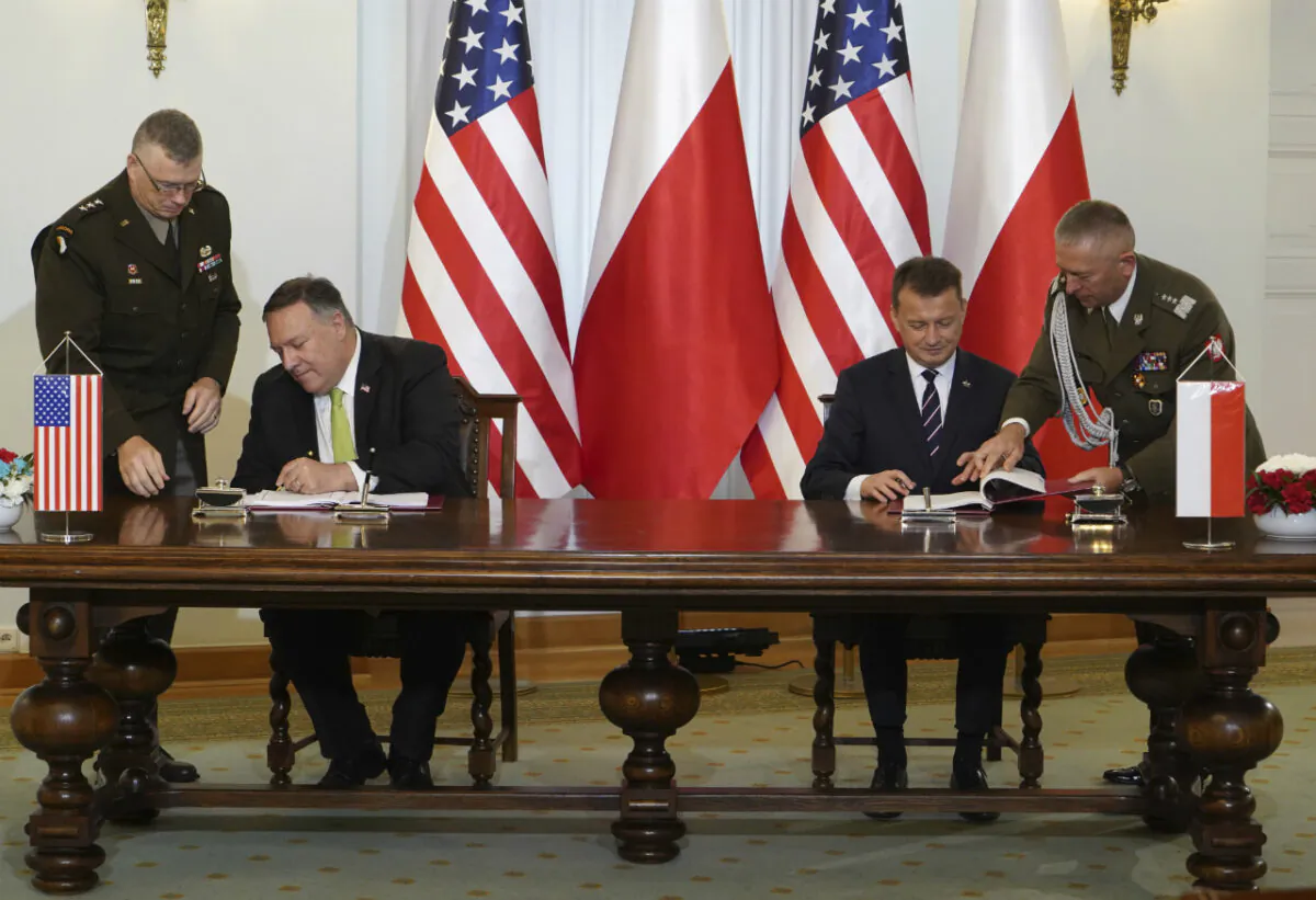 U.S. Secretary of State Mike Pompeo, left, and Poland's Minister of Defense Mariusz Blaszczak sign the U.S.–Poland Enhanced Defense Cooperation Agreement in the Presidential Palace in Warsaw, Poland, on Aug. 15, 2020. (Janek Skarzynski/Pool via AP)