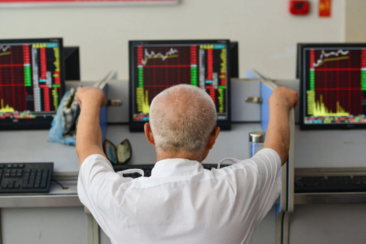 An investor looks at screens showing stock market movements at a securities company in Fuyang in China's eastern Anhui province on July 6, 2020. (STR/AFP via Getty Images)