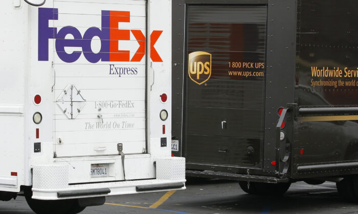 A FedEx truck is parked next to a UPS truck as both drivers make deliveries in San Diego, Calif., on Mar. 5, 2013. (Mike Blake/Reuters)