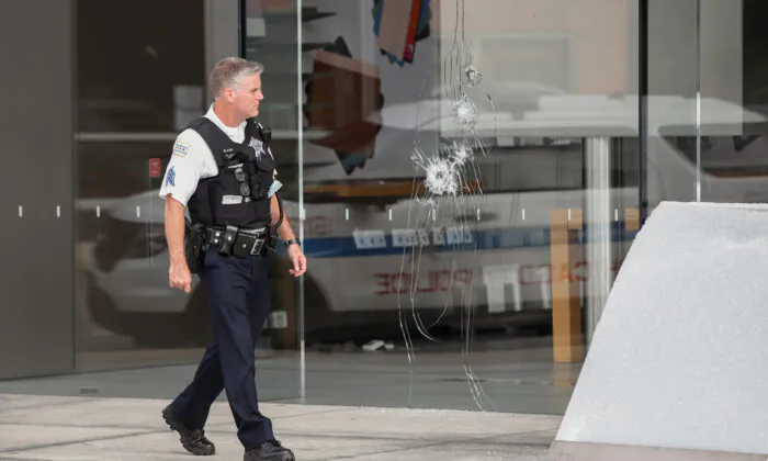 A Chicago police officer inspects an Apple store that was vandalized in Chicago on Aug. 10, 2020. (Kamil Krzaczynski/Reuters)
