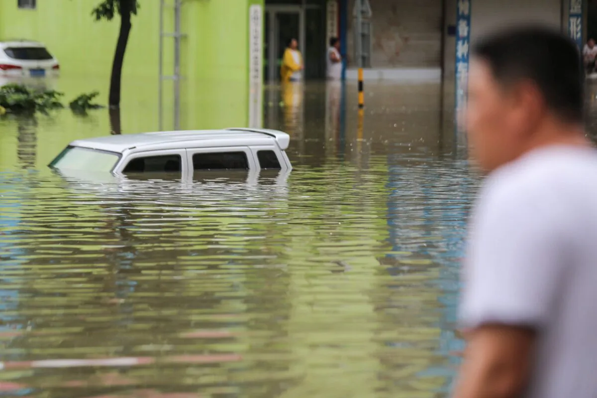 A man looks out at vehicles stuck along a flooded street after heavy rains hit the area in Linyi, in China's eastern Shandong Province, on Aug. 14, 2020. (STR/AFP via Getty Images)