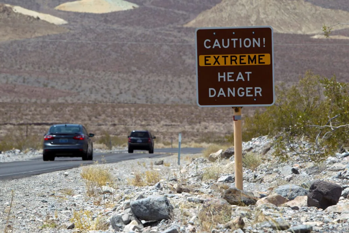 Sara Calcinaro (L) and Marco Rizzelli of Italy walk in the Mesquite Dunes as high temperatures approach record levels in Death Valley National Park, Calif., on June 29, 2013. (File Photo via Reuters)