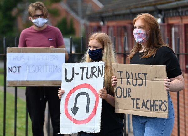 UK students hold placards as they protest against the downgrading of A-level results in central England.