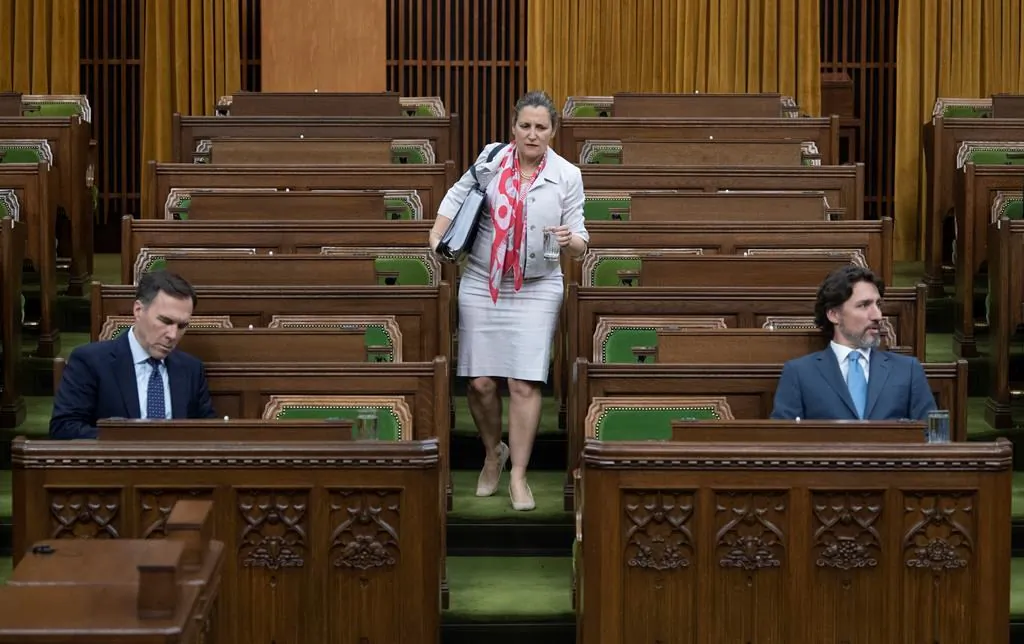 Deputy Prime Minister and Minister of Intergovernmental Affairs Chrystia Freeland looks for a seat as Finance Minister Bill Morneau and Prime Minister Justin Trudeau wait for a session of the Special Committee on the COVID-19 Pandemic to begin in the Chamber of the House of Commons in Ottawa on May 13, 2020. (Adrian Wyld/The Canadian Press)