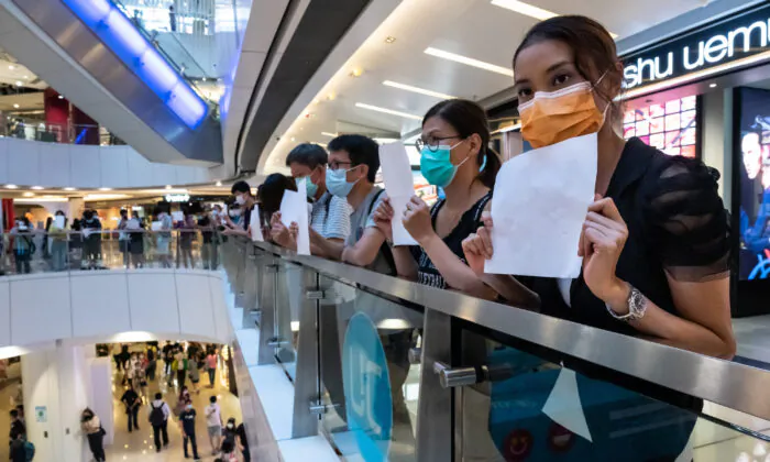 Protesters hold up blank papers during a demonstration in a mall in Hong Kong, on July 6, 2020. Hong Kongers are finding creative ways to voice dissent as police began making arrests for people displaying now forbidden political slogans. (Billy H.C. Kwok/Getty Images)
