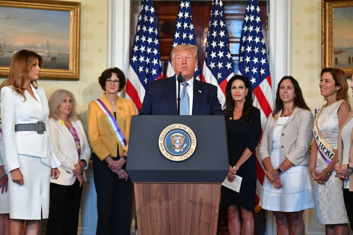 President Donald Trump, front, takes part in the signing of a proclamation on the 100th anniversary of the ratification of the 19th Amendment during an event in the Blue Room of the White House in Washington on Aug. 18, 2020. (Mandel Ngan/AFP via Getty Images)