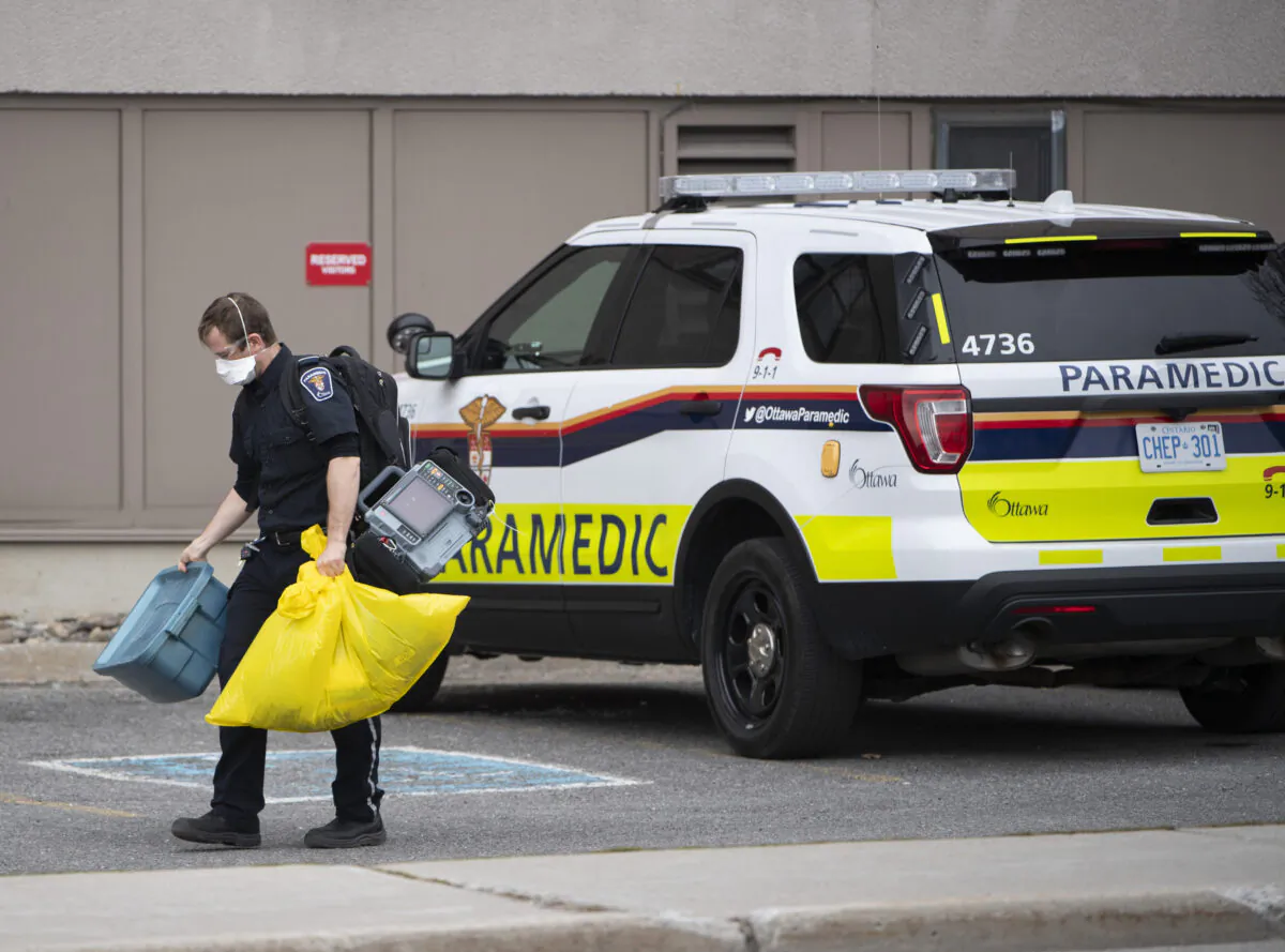A paramedic walks toward the entrance of a long-term care home experiencing a COVID-19 outbreak in Ottawa on April 26, 2020. (The Canadian Press/Justin Tang)