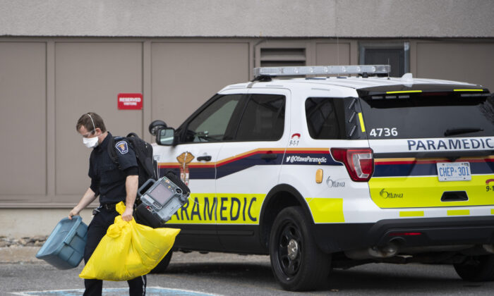 A paramedic walks toward the entrance of a long-term care home experiencing a COVID-19 outbreak in Ottawa on April 26, 2020. (The Canadian Press/Justin Tang)