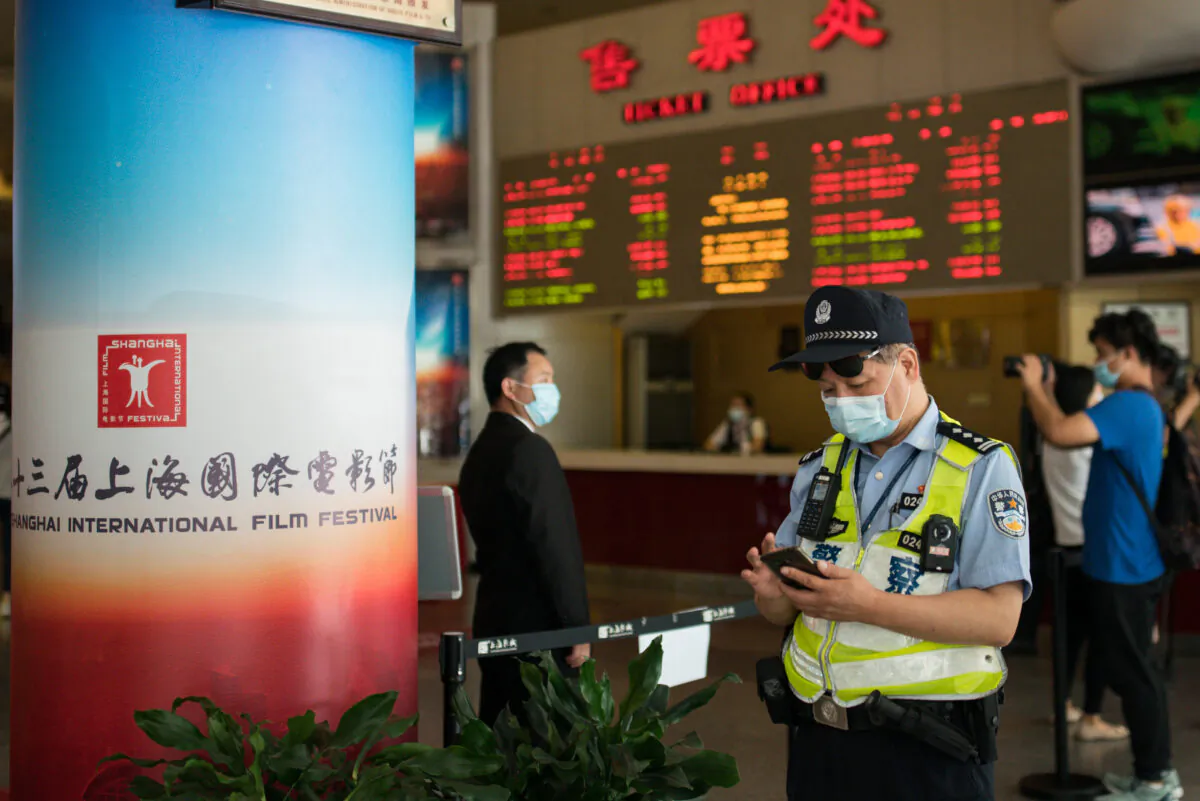 A police officer looks at his cell phone at Shanghai Film Center (SFC) in Shanghai on July 25, 2020. (Yifan Ding/Getty Images)