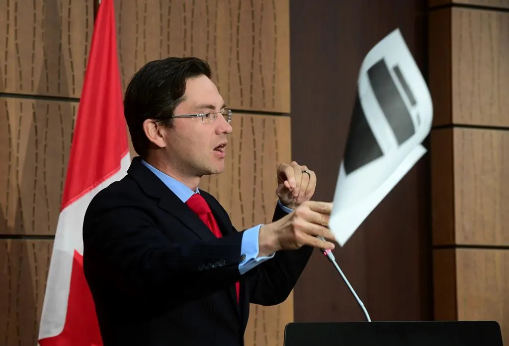 Conservative MP Pierre Poilievre throws a redacted document tabled at the House of Commons Finance Committee provided by the Government during a press conference on Parliament Hill in Ottawa on Aug. 19, 2020. (Sean Kilpatrick/The Canadian Press)