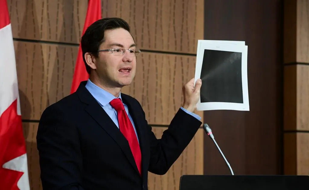 Conservative MP Pierre Poilievre holds up redacted documents during a press conference on Parliament Hill in Ottawa on Aug. 19, 2020. The documents were tabled by the Government at the House of Commons Finance Committee. (Sean Kilpatrick/The Canadian Press)