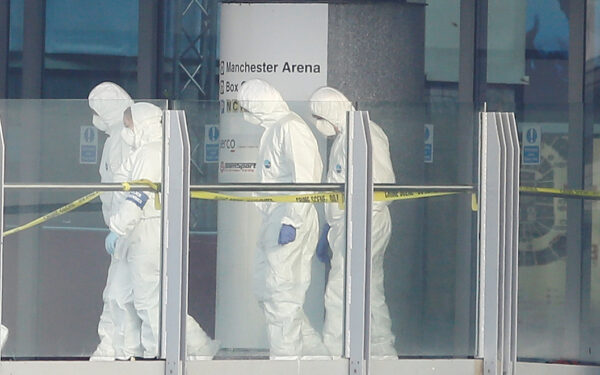 forensics investigators working at the entrance of the Manchester Arena,