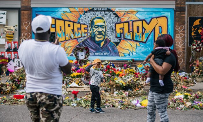 A family takes pictures in front of a mural of George Floyd in Minneapolis, Minn., on May 28, 2020. (Brandon Bell/Getty Images)