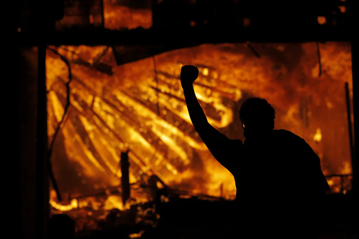  A protester gestures in front of the burning 3rd Precinct building of the Minneapolis Police Department in Minneapolis, Minn., on May 28, 2020. (Julio Cortez File/AP Photo)