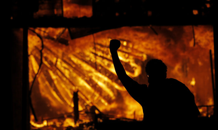  A protester gestures in front of the burning 3rd Precinct building of the Minneapolis Police Department in Minneapolis on May 28, 2020. (Julio Cortez File/AP Photo)