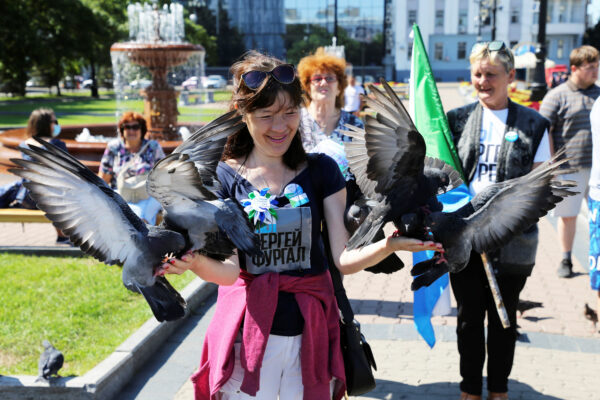A participant feeds pigeon anti-Kremlin rally-support of Sergei Furgal