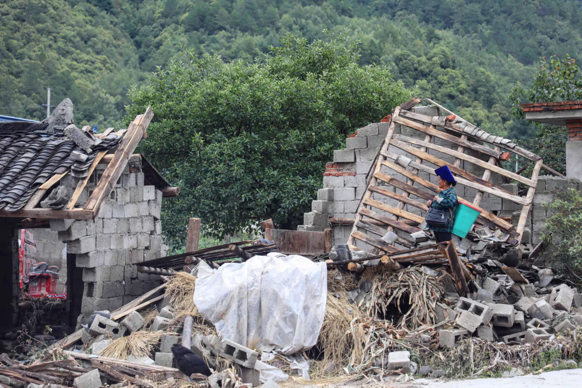A woman looks at the aftermath of flooding caused by heavy rainfall in Mianning county, in  
the Liangshan Yi Prefecture, in southwestern Sichuan Province, China, on June 28, 2020. (STR/AFP via Getty Images)