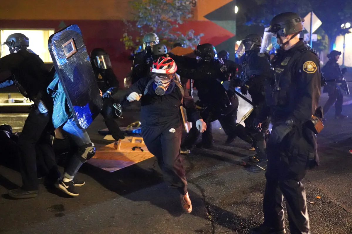 Protesters and Portland police clash while dispersing a crowd gathered in front of the Portland Police Bureau North Precinct early in the morning in Portland, Ore., on Aug. 22, 2020. (Nathan Howard/Getty Images)