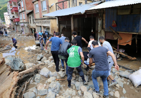 People carry a rescued person from the scene after floods