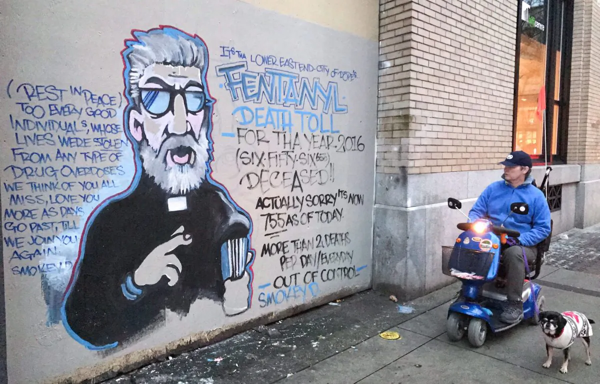 A man stops to read a mural about the fentanyl and opioid overdose crisis, in the Downtown Eastside of Vancouver, in a file photo. (Darryl Dyck/The Canadian Press)