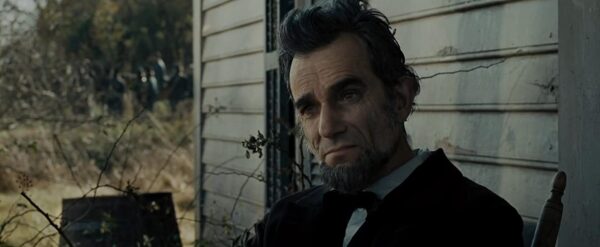 man sitting on porch in "Lincoln"