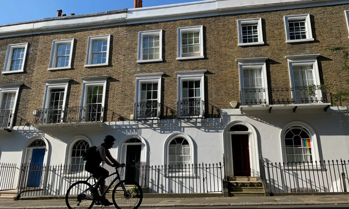 A person on a bicycle rides past houses on a street in Islington, London, on June 22, 2020. (Simon Newman/Reuters)