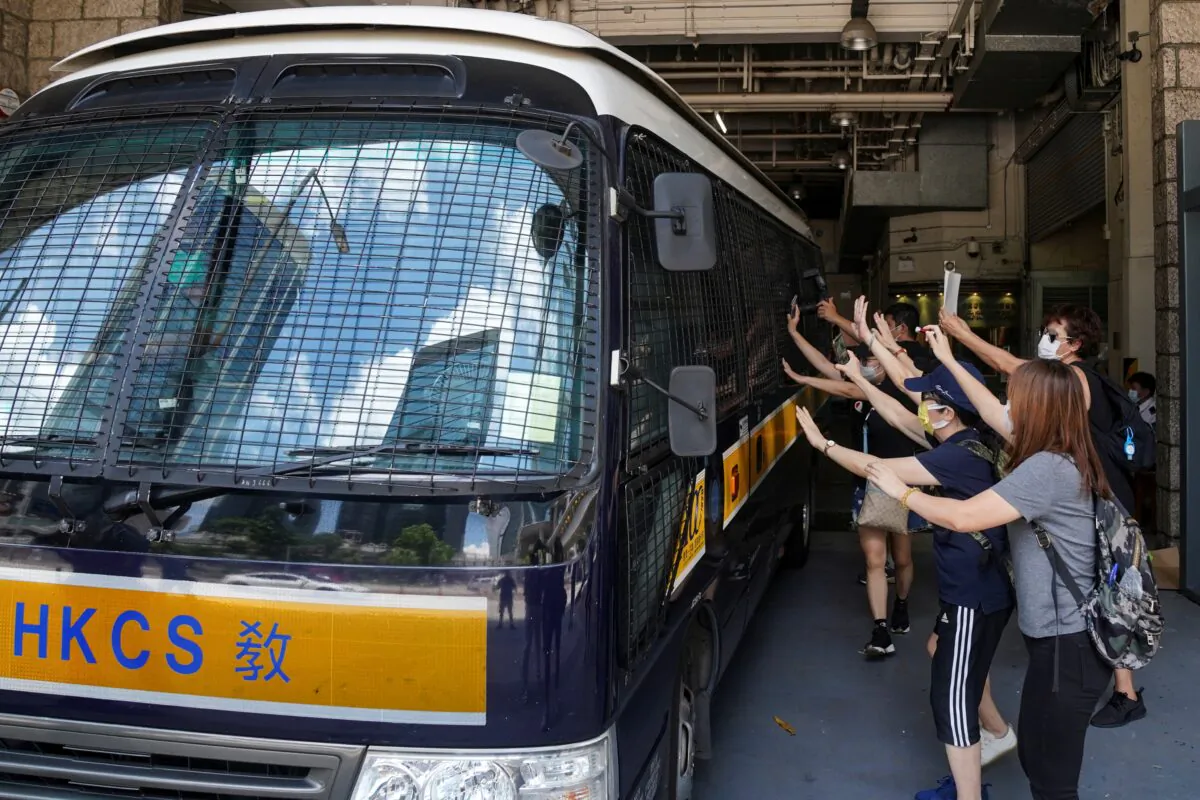 Supporters bid farewell to a prison van transporting Tong Ying-kit, a Hong Kong resident charged under the city's new national security law, who has been denied bail again in Hong Kong, China, on Aug. 25, 2020. (Lam Yik via Reuters)