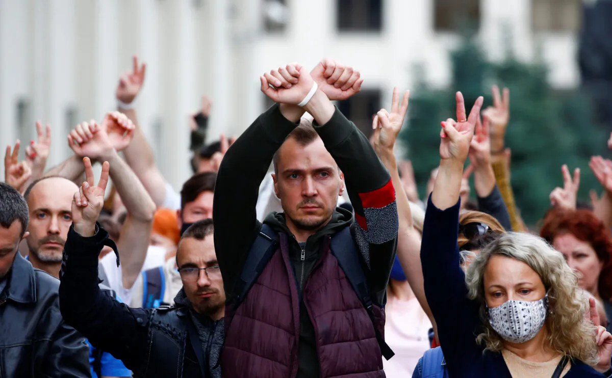 People gesture as they take part in a rally against presidential election results near the Ministry of Education in Minsk on August 25, 2020. (Vasily Fedosenko/Reuters)