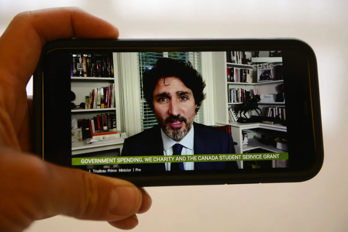 Prime Minister Justin Trudeau is viewed on a mobile phone as he appears as a witness via videoconference during a House of Commons finance committee in the Wellington Building on Thursday, July 30, 2020. The committee is looking into Government Spending, WE Charity and the Canada Student Service Grant.  THE CANADIAN PRESS/Sean Kilpatrick