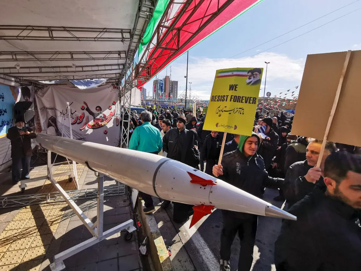 Iranians walk past a replica of a rocket during commemorations marking 41 years since the Islamic Revolution, in the capital Tehran on Feb. 11, 2020. (ATTA KENARE/AFP via Getty Images)