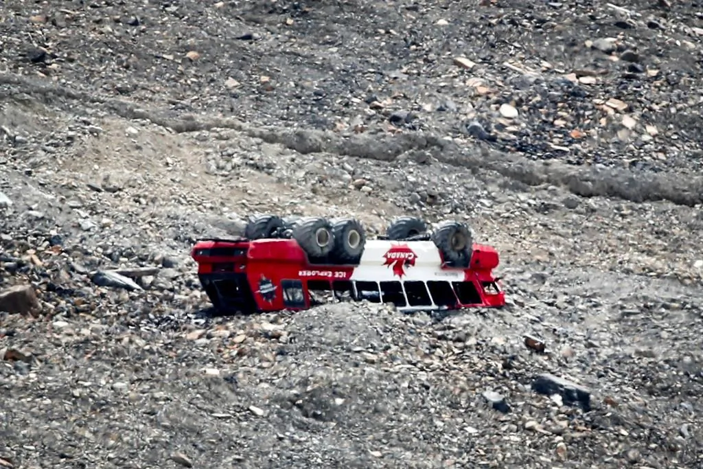 A rolled-over tour bus rests where it fell on the Columbia Icefield near Jasper, Alta., July 19, 2020. A class-action lawsuit alleging the defendants acted recklessly and unreasonably has been filed against the operators of a tour bus involved in a fatal rollover at Jasper National Park's Columbia Icefield. (Jeff McIntosh/The Canadian Press)
