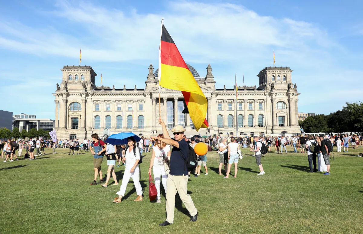 A demonstrator holds a German flag near the Reichstag during a protest against the government's restrictions imposed over the coronavirus outbreak, in Berlin, on Aug. 1, 2020. (Christian Mang/Reuters)