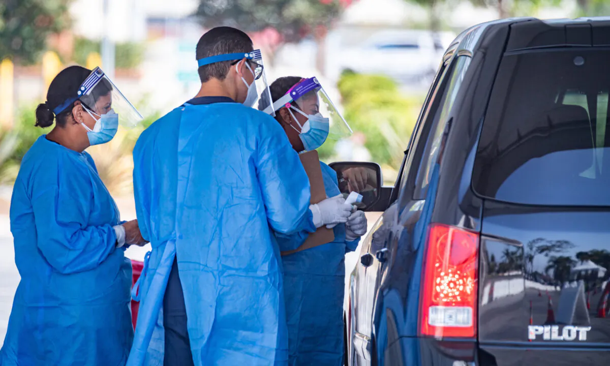 Health care workers administer a drive-through COVID-19 test at a new testing super site at the Orange County Fair & Event Center in Costa Mesa, Calif., on Aug. 26, 2020. (John Fredricks/The Epoch Times)