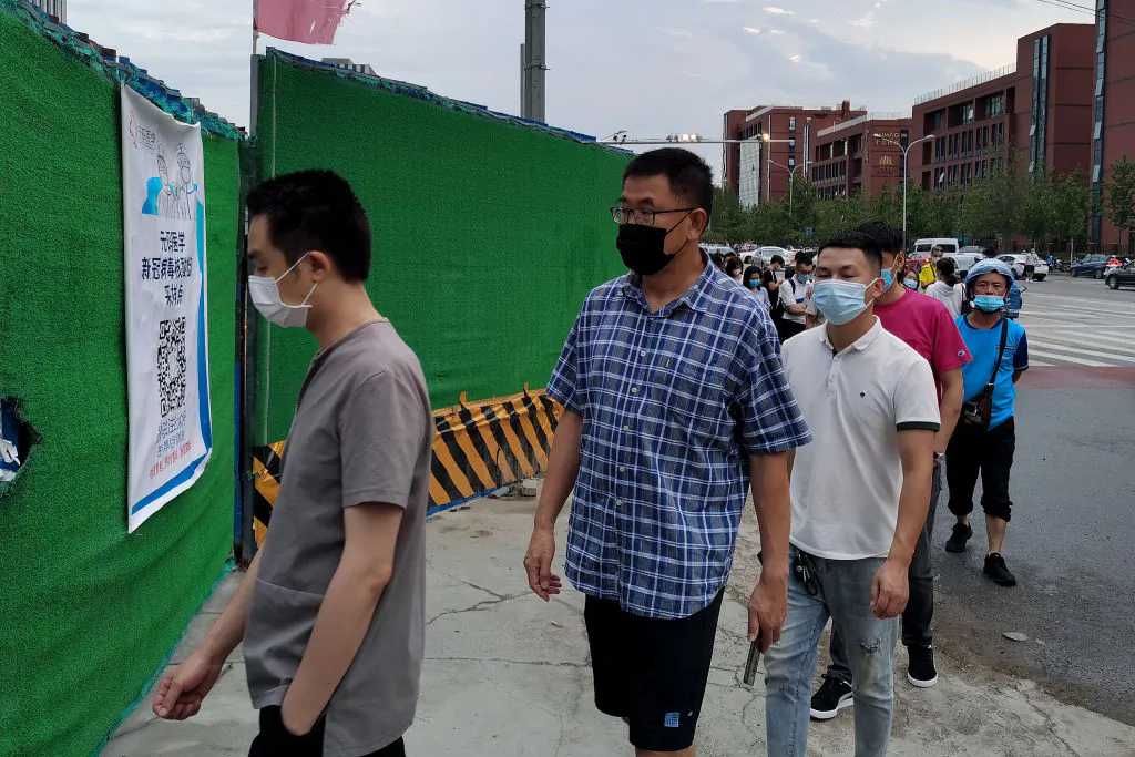 People wear protective masks as they wait in line to undergo COVID-19 coronavirus swab tests at a temporary test station in Beijing on July 6, 2020. (Lintao Zhang/Getty Images)