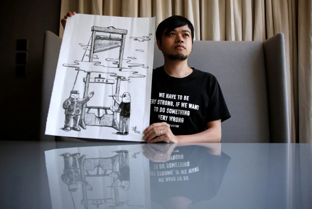 Political illustrator Ah To poses with his work "Guillotine" after his cartoon column in one of the city's popular news magazines will get axed in Hong Kong, China, on July 28, 2020. (Tyrone Siu/Reuters)