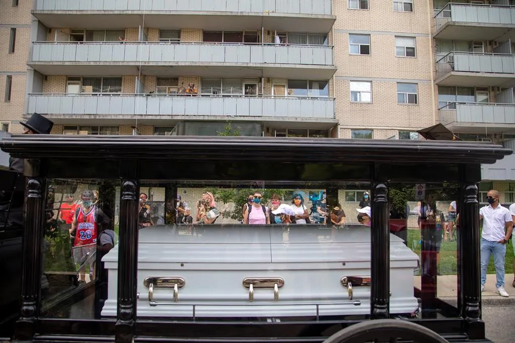 A horse drawn carriage carrying a white coffin was part of a public memorial held to honour Regis Korchinski-Paquet, a woman who fell to her death from a balcony while police were in her apartment in Toronto on July 25, 2020. A new report from Ontario's police watchdog found no evidence of police wrongdoing or racism in the incident. (Carlos Osorio/The Canadian Press)