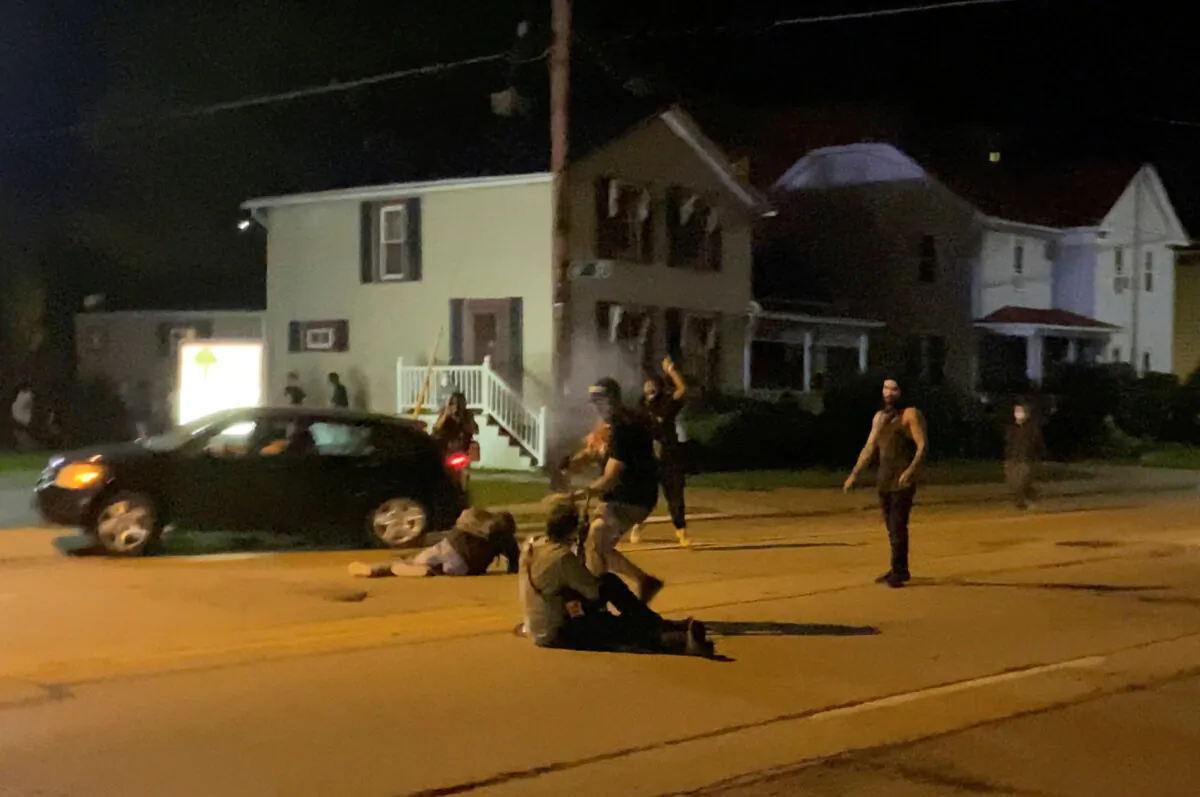 A man is being shot in his arm during a protest following the police shooting of Jacob Blake, in Kenosha, Wis., on Aug. 25, 2020. (Brendan Gutenschwager/via Reuters)