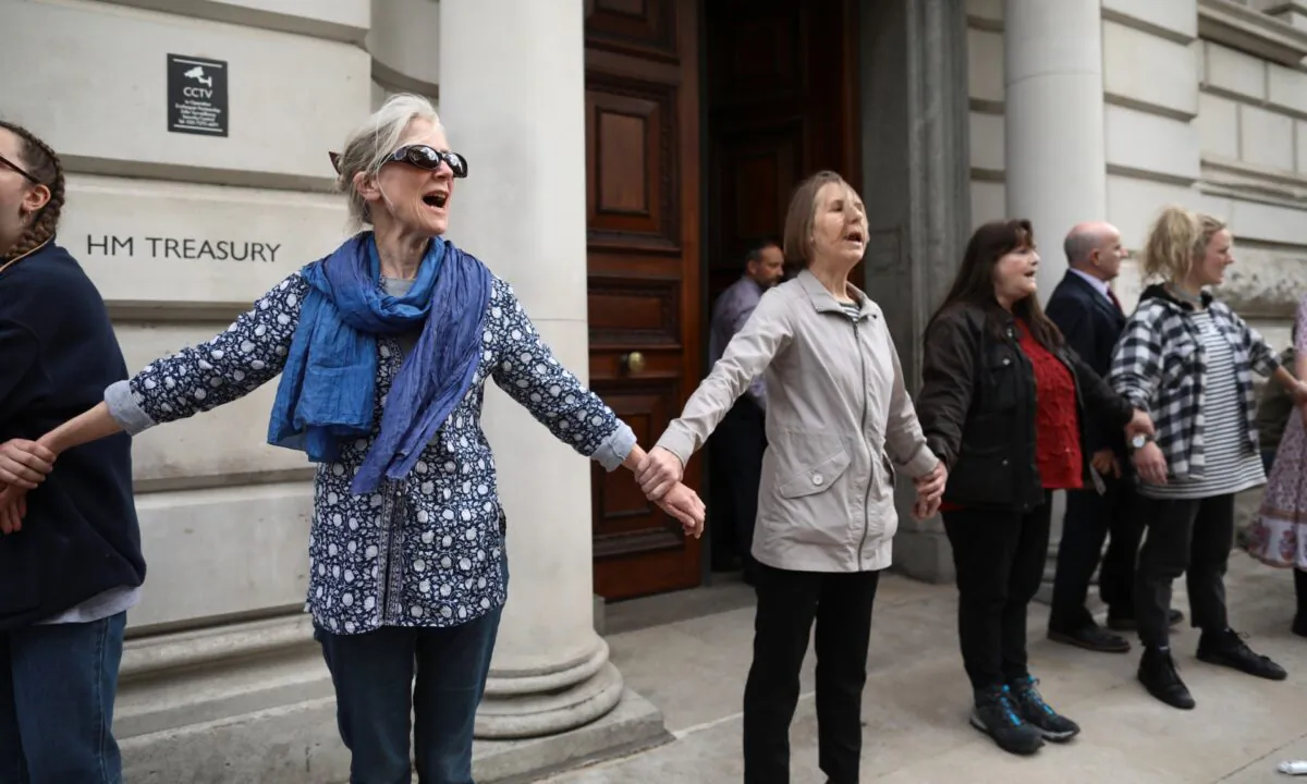 Environmental campaigners from the "Extinction Rebellion" group glue themselves together outside Her Majesty's Treasury as part of their ongoing actions and protests across the capital, in London, on April 25, 2019. (Dan Kitwood/Getty Images)