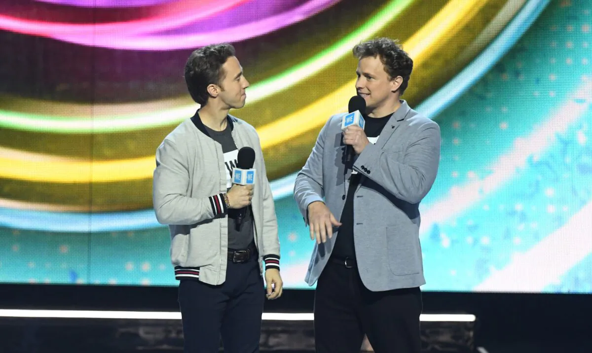 Co-founders of WE Charity co-founders Craig (L) and Marc Kielburger speak on stage during WE Day California at the Forum in Inglewood, Calif., on April 25, 2019. (Valerie Macon/AFP via Getty Images)