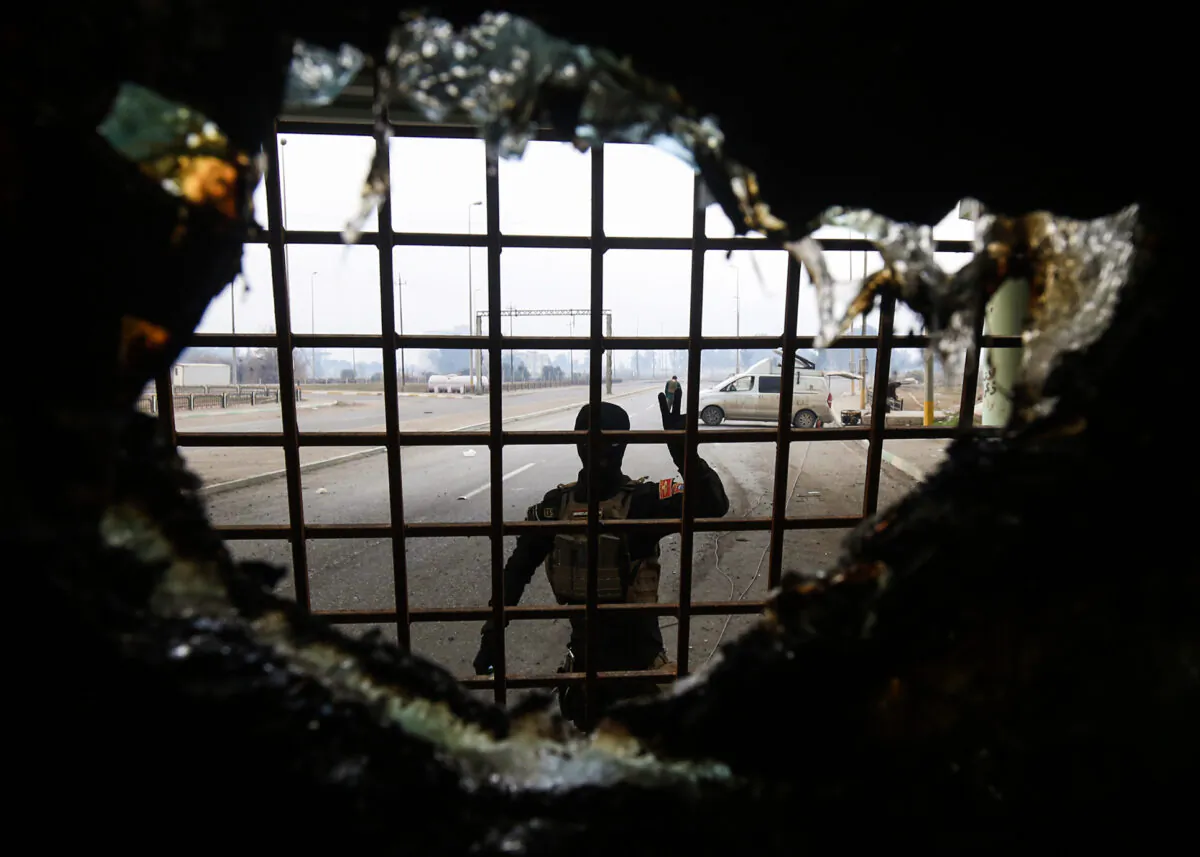 A member of the Iraqi counter-terrorism service (CTS) flashes the V-gesture as he stands near a rigged vehicle that was dismantled in Mosul after government forces retook control of the area from the ISIS terrorist group on Jan. 21, 2017. (Ahmad Al-Rubaye/AFP via Getty Images)