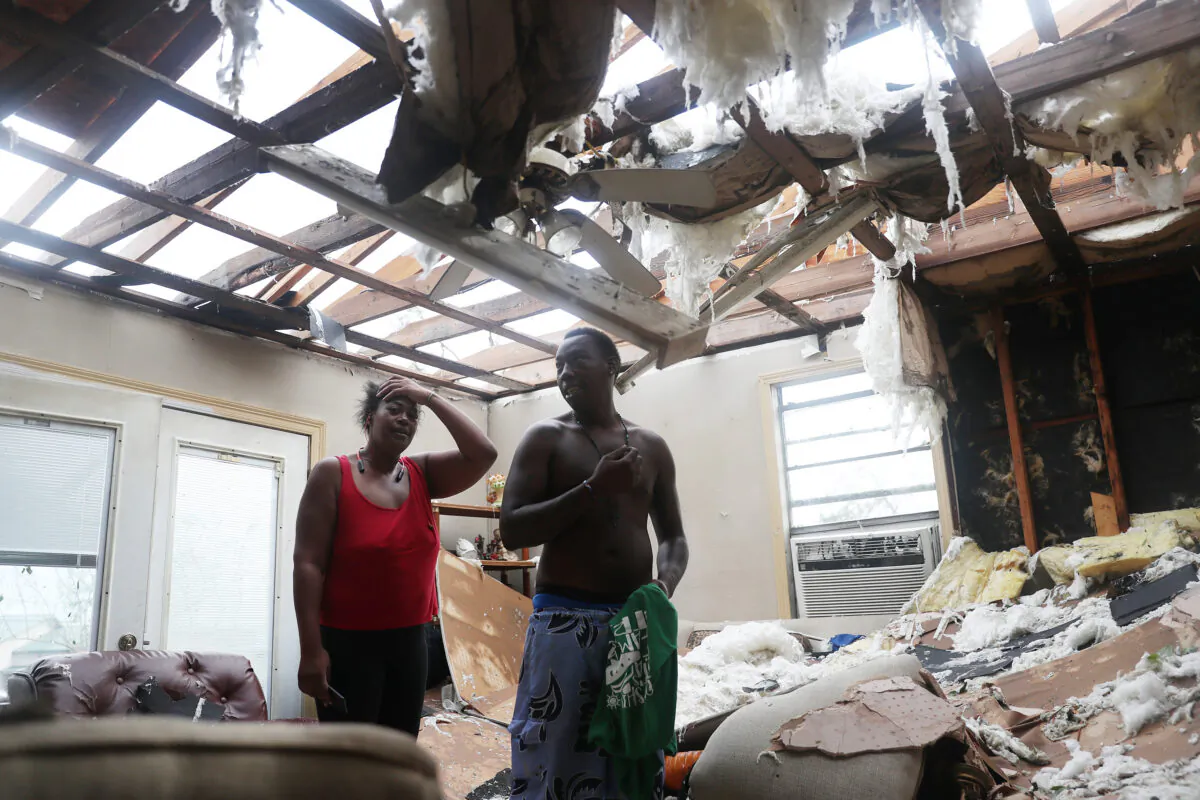 Latasha Myles and Howard Anderson stand in their living room where they were sitting when the roof blew off around 2:30 a.m. as Hurricane Laura passed through the area in Lake Charles, La., on Aug. 27, 2020. (Joe Raedle/Getty Images)
