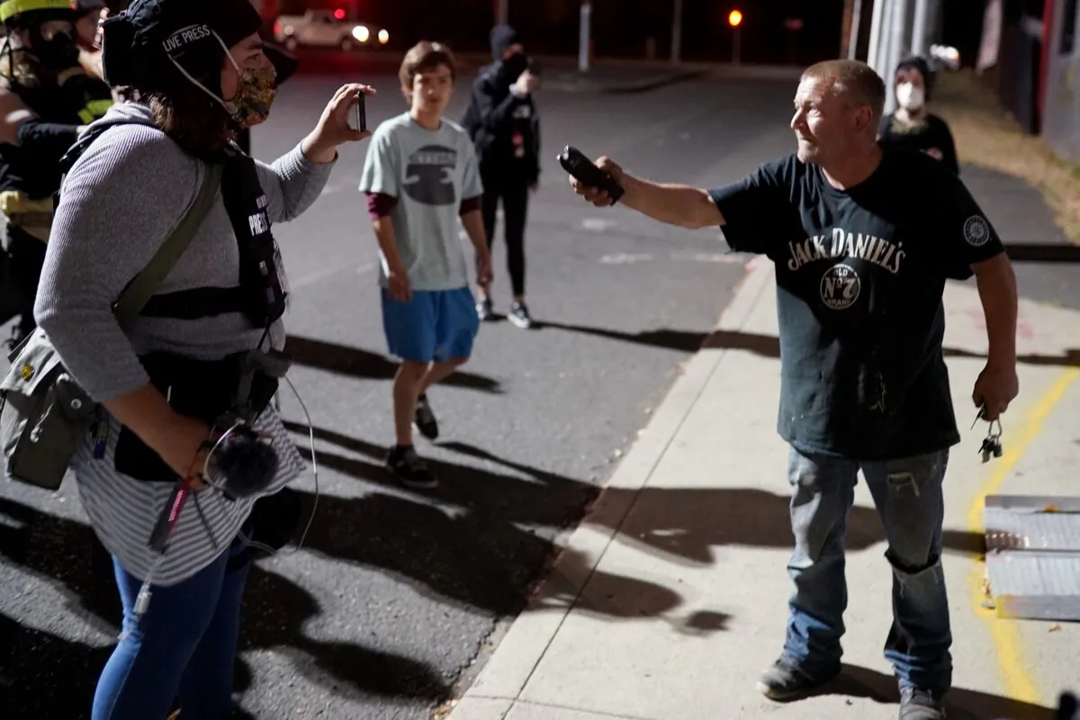 A man brandishes a stun gun during an argument with demonstrators after they went to his business in the South Waterfront neighborhood in Portland, Ore., on Aug. 20, 2020. (Nathan Howard/Getty Images)