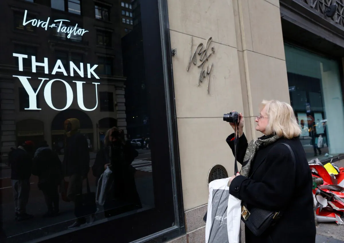 A woman, who declined to give her name, pauses to take a photo of a sign outside Lord & Taylor's flagship Fifth Avenue store in New York, N.Y., on Jan. 2, 2019. (Kathy Willens/AP Photo)