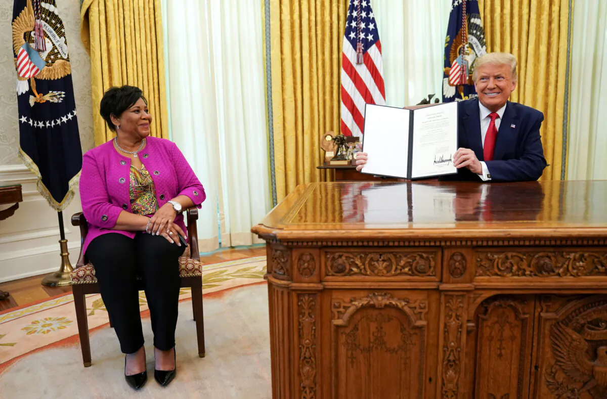 Alice Johnson, who received a life sentence for a first-time drug offense, receives a pardon from President Donald Trump in the Oval Office of the White House in Washington, on Aug. 28, 2020.  (Kevin Lamarque/Reuters)