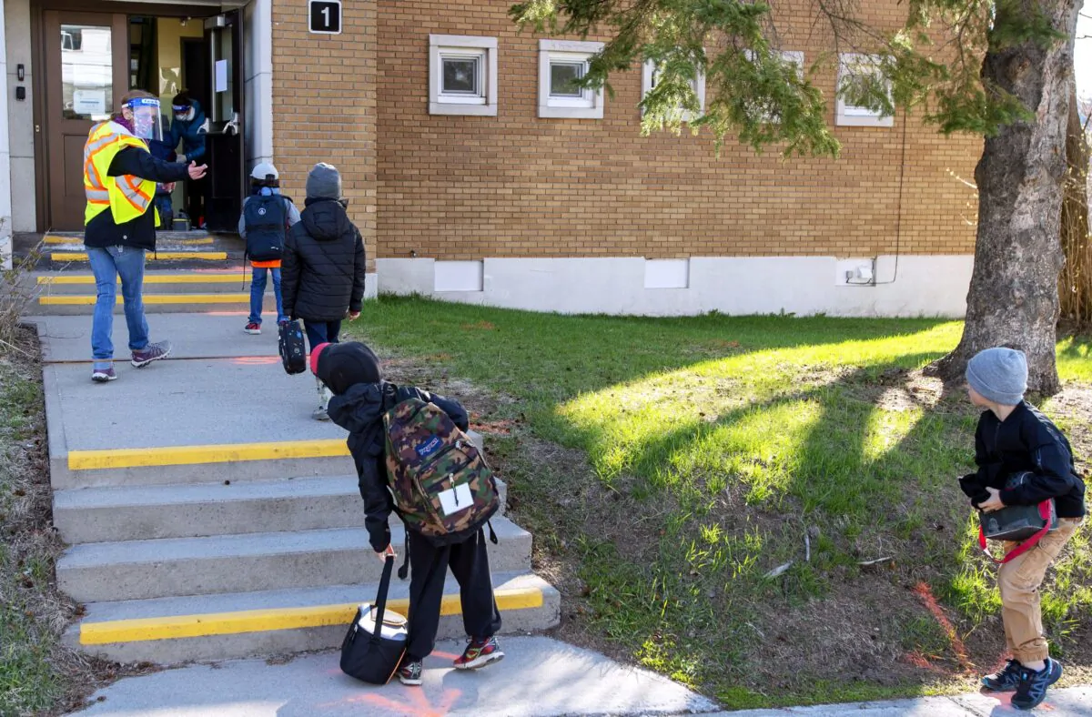 Students maintain social distancing as they enter Ecole Marie Rose in Saint Sauveur, Que., as elementary schools outside the greater Montreal area reopen on May 11, 2020. (The Canadian Press/Ryan Remiorz)