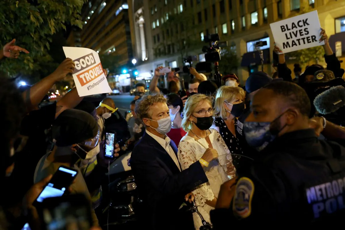 Black Lives Matter demonstrators surround Sen. Rand Paul (R-Ky.) and several women in Washington, early Aug. 28, 2020. (Leah Millis/Reuters)
