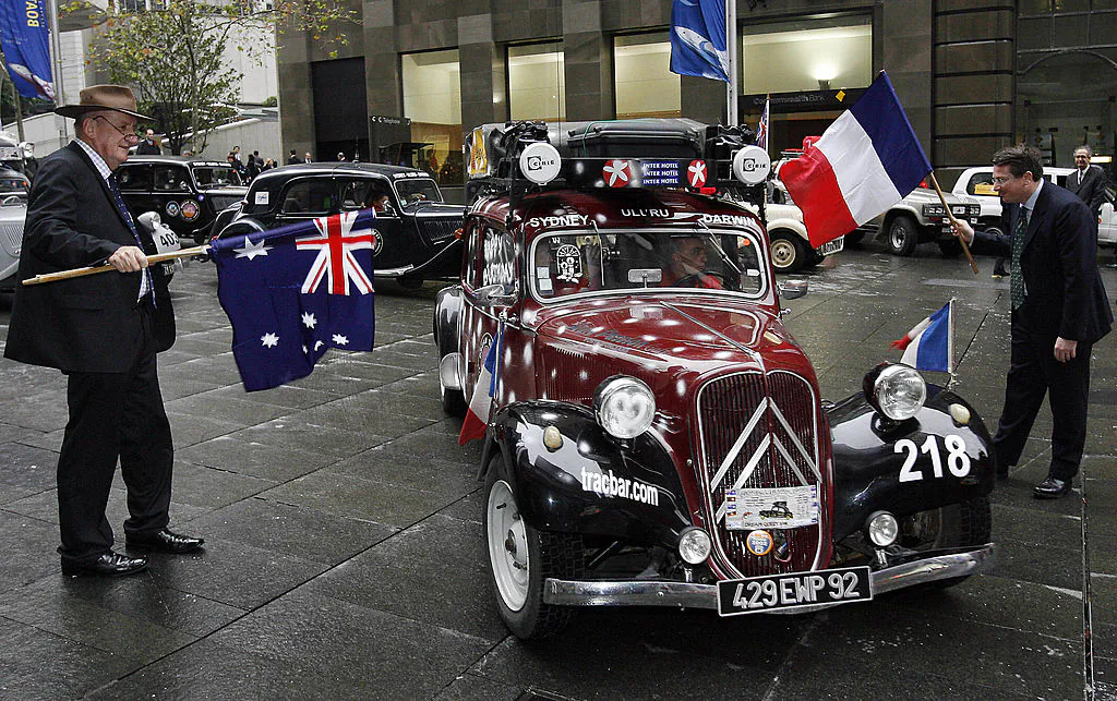 Former Australian deputy-prime minister Tim Fischer (L) and French Consul General Laurent Delahousse (R) flag off 20 classic Citroen Traction Avant cars, built in France between 1934 and 1957, at the start of the 2006 Dreamquest trans-Australia trek in Sydney, 26 July 2006.(TORSTEN BLACKWOOD/Getty Images)